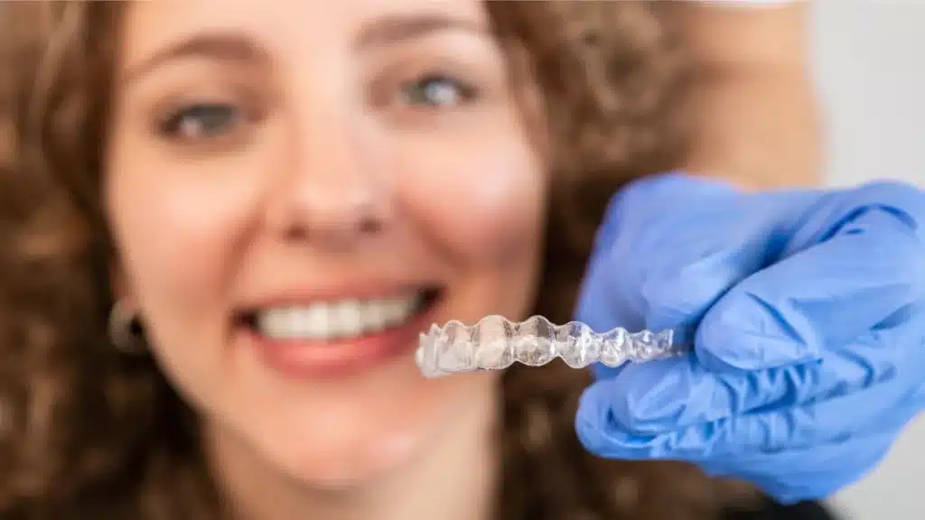 imagen de mujer sonriendo y un aparato de ortodoncia invisible