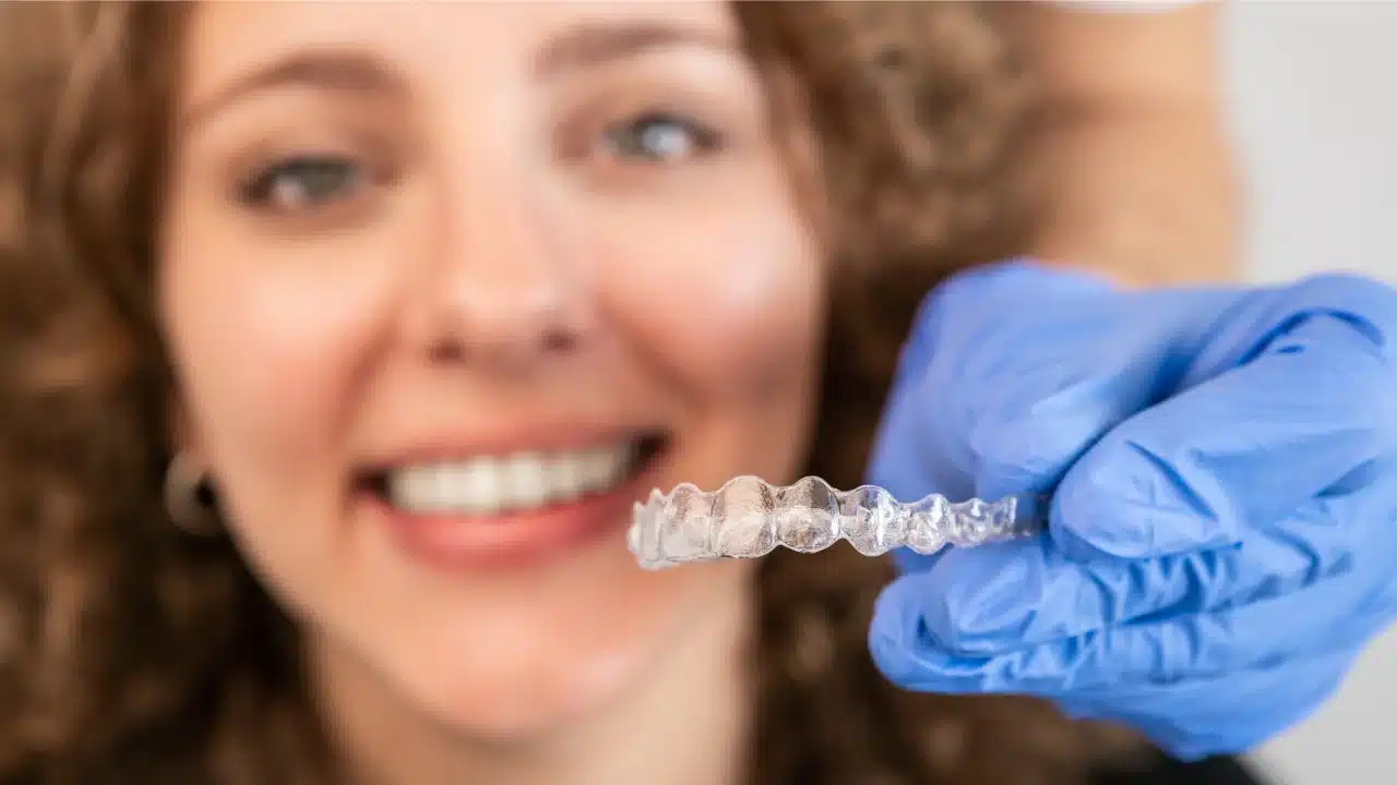 imagen de mujer sonriendo y un aparato de ortodoncia invisible
