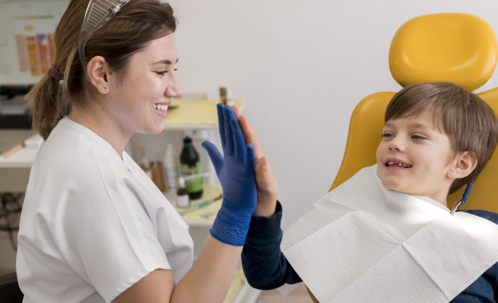 niño sonriendo con una dentista en una revisión bucodental