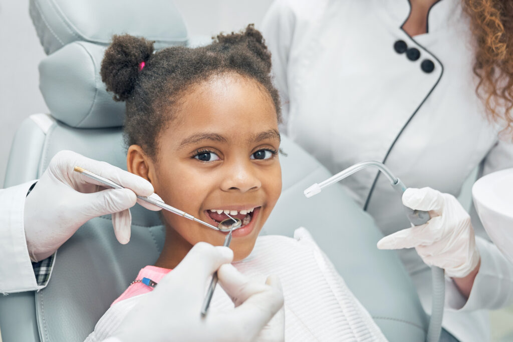 nina-afro-feliz-en-chequeo-regular-de-dientes-en-clinica-dental